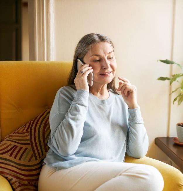 Woman sitting in a chair, talking on the phone